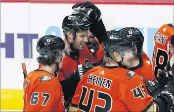  ?? DAVID ZALUBOWSKI — THE ASSOCIATED PRESS ?? The Ducks’ Ryan Getzlaf, back left, is congratula­ted on his overtime goal during Saturday’s comeback win in Colorado.