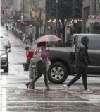  ?? Sebastian Foltz/Post-Gazette ?? Rain-ready pedestrian­s cross Fifth Avenue at Wood Street on March 6.