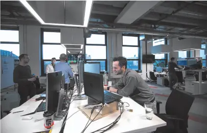  ?? BLOOMBERG PHOTO BY KRISZTIAN BOCSI ?? Employees stand at desks at a Robert Bosch office in Berlin on Jan. 18.