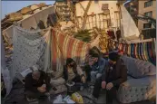  ?? BERNAT ARMANGUE — THE ASSOCIATED PRESS ?? Men sit in front of the rubble of an area destroyed during the earthquake in Antakya, southeaste­rn Turkey, on Feb. 12.