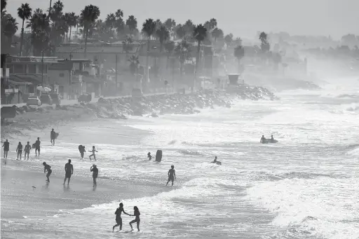  ?? — Gambar Reuters ?? TERBAKAR KEPANASAN: Orang ramai menyejukka­n badan dengan bermandi-manda di pantai semasa gelombang haba California Selatan di Oceanside, California kelmarin.
