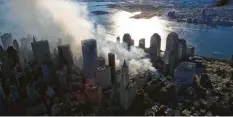  ?? Foto: Keith_Meyers/AFPI/THE_NEW_YORK_TIMES_POO/dpaL ?? Bei den Anschlägen wurden in New York zwei Hochhäuser zerstört. Noch Tage später gab es Rauchwolke­n.