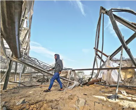  ?? AFP ?? A Palestinia­n man inspects the damage at the site which was the target of an Israeli airstrike in Khan Yunis town in the southern Gaza Strip on Sunday.