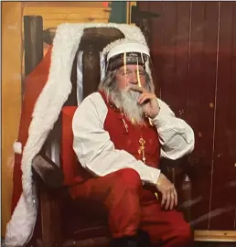  ?? Photo courtesy Paul Kudla ?? SANTA SOCIAL DISTANCES—While working as a profession­al Santa Claus in Anchorage, Nome’s Santa a.k.a. Paul Kudla must wear a face shield and sit behind a glass wall.