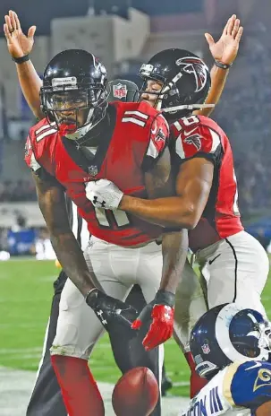  ?? THE ASSOCIATED PRESS ?? Atlanta Falcons wide receiver Julio Jones (11) celebrates after scoring a touchdown during a playoff victory against the Rams in Los Angeles last January. Jones reported to training camp on time Thursday, less than 24 hours after the Falcons announced they would renegotiat­e his contract next year.