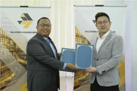  ??  ?? MajuPerak group chief executive officer Nizran Noordin (left) and Lagenda Properties managing director Datuk Doh Jee Ming exchanging documents at the signing ceremony.