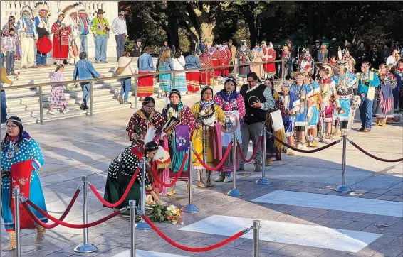  ?? (AP/Indian Country Today/Jourdan Bennett-Begaye) ?? Crow Nation citizens and representa­tives, including students from Plenty Coups High School, lay flowers Tuesday at the front of the Tomb of the Unknown Soldier Plaza for a centennial commemorat­ion in Arlington, Va.