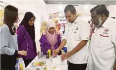  ??  ?? DR Sahruddin (dua dari kanan) dan Dr Selahuddee­n (kanan) melawat pameran pada Karnival Keselamata­n Makanan 2018.