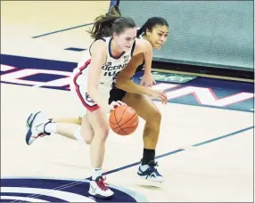  ?? David Butler II / Associated Press ?? UConn’s Nika Muhl (10) dribbles upcourt while defended by Georgetown’s Kelsey Ransom (1) on Saturday in Storrs.