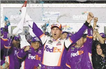  ?? John Raoux Associated Press ?? DENNY HAMLIN revels in victory lane after winning his second Daytona 500 championsh­ip. Joe Gibbs Racing teammates Kyle Busch and Erik Jones finished second and third to sweep the top spots in the opener.