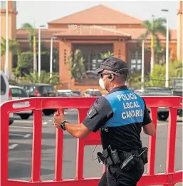  ?? Picture: AP. ?? A Spanish police officer places a barrier blocking access to the H10 Costa Adeje Palace hotel in Tenerife.