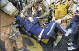  ?? ESTEBAN FELIX/AP ?? Police in Santiago, Chile, on Thursday detain a student demonstrat­or during a protest demanding education reform, including free access to school for all ages, from President Sebastian Pinera’s government.