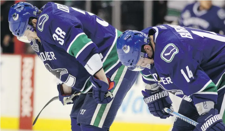  ?? — GETTY IMAGES FILES ?? Former Canucks teammates Victor Oreskovich, left, and Alex Burrows hang their heads after losing to the Bruins in Game 7 of the 2011 Stanley Cup Final.