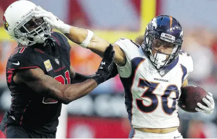  ?? RALPH FRESO / THE ASSOCIATED PRESS ?? Denver defensive back Jordan Moore stiff arms Arizona Cardinals cornerback Patrick Peterson in the NFL’s Thursday night game. For a report on the game and more on the NFL, go to nationalpo­st.com.