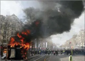  ?? CHRISTOPHE ENA - THE ASSOCIATED PRESS ?? A news stand burns during a yellow vests demonstrat­ion on the Champs Elysees avenue Saturday, March 16 in Paris. French yellow vest protesters clashed Saturday with riot police near the Arc de Triomphe as they kicked off their 18th straight weekend of demonstrat­ions against President Emmanuel Macron.