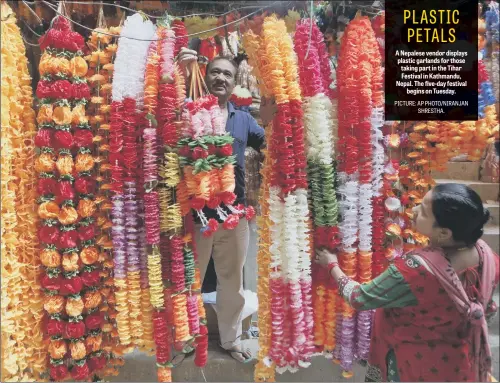  ??  ?? A Nepalese vendor displays plastic garlands for those taking part in the Tihar Festival in Kathmandu, Nepal. The five-day festival begins on Tuesday.