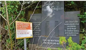  ??  ?? Dieses Schild auf dem Friedhof in Dudweiler weist darauf hin, dass die Nutzungsre­chte für das alte Grab dahinter abgelaufen sind.