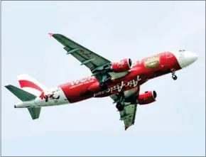  ?? ROSLAN RAHMAN/AFP ?? Low-cost AirAsia Airbus 320 plane prepares to land at Changi Internatio­nal airport in Singapore.