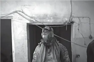  ?? Associated Press ?? leftAn Iraqi Special Forces soldier wears a gas mask Friday after an alleged chemical attack during fighting against Islamic State militants in the Old City of Mosul.