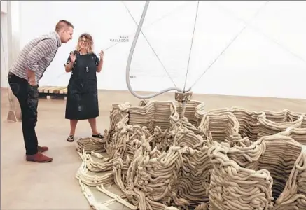  ?? Giana Leone
San Diego Union-Tribune ?? ANYA GALLACCIO and assistant Josh Miller check the progress of her 3-D printer, which is creating a likeness of Devils Tower.