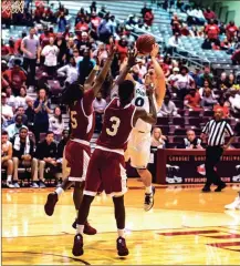  ?? TIM GODBEE / For the Calhoun Times ?? Calhoun’s Rhett Abernathy (0) shoots over Morgan County’s Stevin Green (5) and Josiah Mitchell (3).