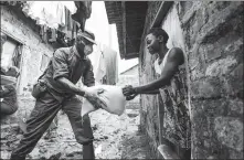  ?? NICHOLAS KAJOBA / XINHUA ?? Military personnel distributi­ng relief supplies in Kampala, capital of Uganda on Saturday. Uganda is supplying food to about 1.5 million people affected by the COVID-19 lockdown.