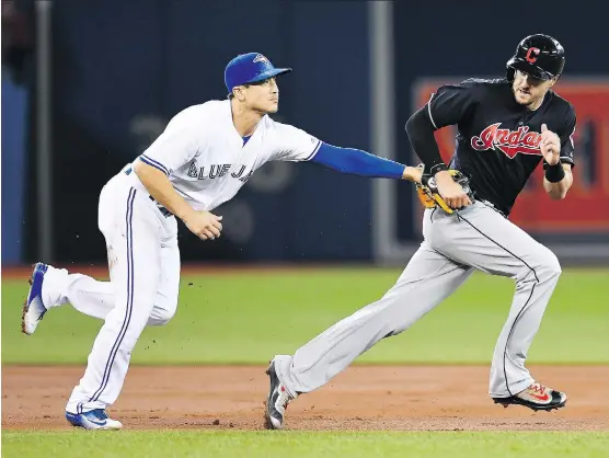  ?? PHOTOS: FRANK GUNN/THE CANADIAN PRESS ?? Cleveland Indians’ Lonnie Chisenhall is tagged out by Blue Jays third baseman Darwin Barney Tuesday during Cleveland’s 6-0 win in Toronto.