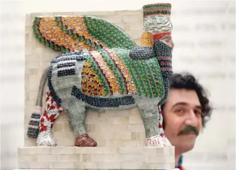  ?? | AP ?? Evanston artist Michael Rakowitz poses at the National Gallery in London next to his design titled “The Invisible Enemy Should Not Exist.” The 15- feet- tall replica of an Assyrian winged- bull will soar over tourists in London’s Trafalgar Square...