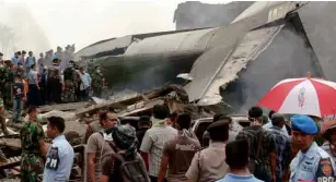  ?? AP ?? MILITARY personnel inspect the wreckage of an Air Force cargo plane with 12 crew aboard that crashed in Medan, North Sumatra, Indonesia, on Tuesday.