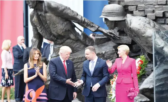  ??  ?? US President Donald Trump, 2nd left, his wife Melania Trump, left, and the Polish President Andrzej Duda and his wife Agata Kornhauser-Duda, right, stand in front of the Warsaw Uprising Monument in Krasinski Square after Donald Trump gave a speech...