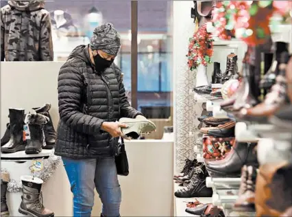  ?? JOHN J. KIM/CHICAGO TRIBUNE PHOTOS ?? Jolly Campbell checks out a pair of shoes Dec. 10 atWesley’s Shoes in Hyde Park.