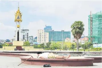  ??  ?? A Cambodian man takes a nap at a park in Phnom Penh. Cambodia’s economy is expected to grow 6.9 per cent this year, compared with a 6.8 per cent in 2017, driven by a recovery in textile exports, tourism and agricultur­al sectors, the World Bank said...