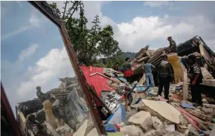  ?? ?? Rescuers look for victims in the rubble of collapsed buildings during a rescue operation. — reuters