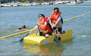  ?? FILE PHOTO ?? Terry Coughlin, left, and Bonnie Jeffcoat dip their oars to propel their Batwoman-themed Yellow Submarine to an exhausting finish during the 2017 World Championsh­ip Cardboard Boat Races.