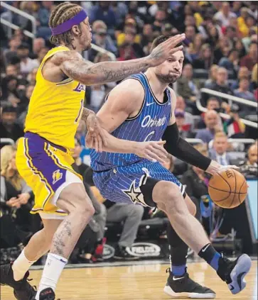  ?? Willie J. Allen Jr. Associated Press ?? NIKOLA VUCEVIC burns Michael Beasley and the Lakers for 36 points and 13 rebounds, scoring clutch baskets repeatedly in the fourth quarter to keep the Magic on top and end L.A.’s four-game winning streak.