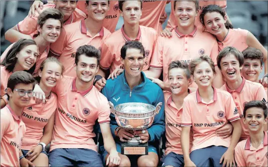  ?? PICTURE: REUTERS ?? CELEBRATIO­N TIME: Spain’s Rafael Nadal celebrates with ball boys, ball girls and the trophy after winning the French Open the final against Austria’s Dominic Thiem yesterday.