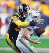  ?? KEITH SRAKOCIC/ASSOCIATED PRESS ?? Pittsburgh’s T.J. Watt, left, brings down Miami quarterbac­k Ryan Fitzpatric­k for a sack during the Steelers’ win over the Dolphins Monday.