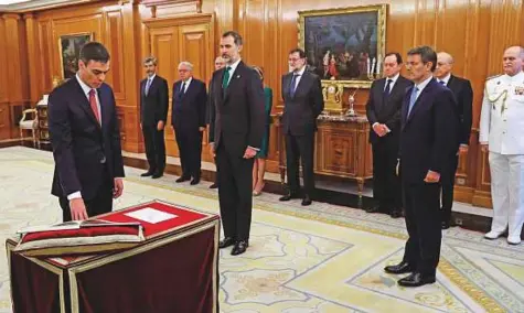  ?? AP ?? Spain’s socialist leader Pedro Sanchez takes his oath of office in the presence of Spain’s King Felipe VI and former Prime Minister Mariano Rajoy (behind King Felipe) at Zarzuela Palace on the outskirts of Madrid, Spain, yesterday.