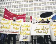  ?? ?? Protesters carry placards against banks in front of the central bank at Hamra street in Beirut, Lebanon, Jan. 23, 2022.