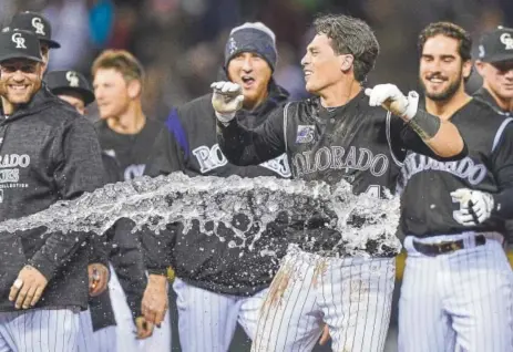  ?? Dustin Bradford, Getty Images ?? Tony Wolters is doused with water Saturday night at Coors Field after giving the Rockies a 3-2 victory over the Braves by drawing a walk-off walk in the 10th inning. Wolters, a catcher, went 2-for-3 in addition to his winning walk.