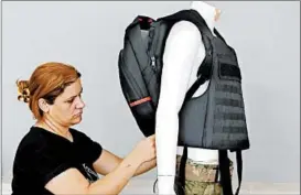  ?? AHMAD GHARABLI/GETTY-AFP ?? A Masada Armour employee adjusts a bulletproo­f backpack for school children in a demonstrat­ion Thursday at the firm’s headquarte­rs in Julis, Israel. The backpack weighs 61⁄ pounds and is supposed to protect against a 9mm round.