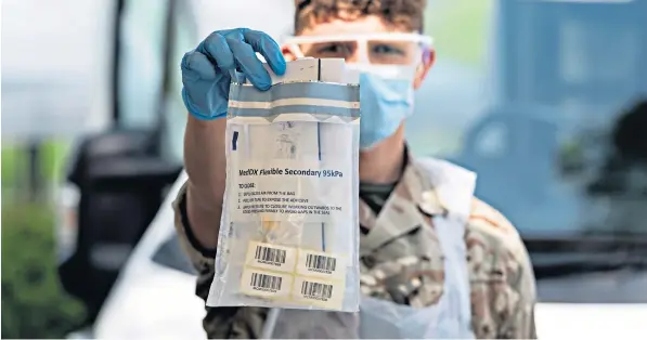  ??  ?? A soldier holds up a Covid-19 testing kit at Kendal Leisure Centre in Cumbria, where the 1st Battalion The Duke of Lancaster’s Regiment has been providing a mobile testing facility