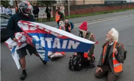  ?? Photograph: Guy Smallman/Getty Images ?? A biker grabs a banner from an Insulate Britain protester in Thurrock, Essex.