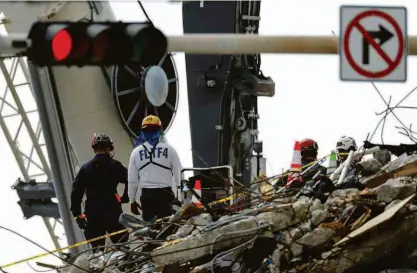  ?? Marco Bello/reuters ?? Equipes de resgate buscam vítimas de desabament­o em Surfside, na Flórida; ainda há 128 desapareci­dos na tragédia que já deixou 20 mortos. Brasileira conta como escapou de apartament­o no 11º andar