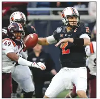  ?? AP/JOHN RAOUX ?? Oklahoma State quarterbac­k Mason Rudolph (2) throws a pass Thursday as he is pressured by Virginia Tech linebacker Tremaine Edmunds (49) during the Camping World Bowl in Orlando, Fla.