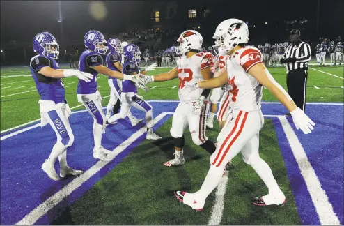  ?? Matthew Brown / Hearst Connecticu­t Media ?? Players from Darien, left, and Greenwich shake hands before a Class LL state quarterfin­al in December.