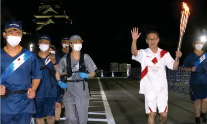  ?? ?? The Olympic flame being carried near Kumamoto castle, south-western Japan, on 6 May. Japan is extending its Covid state of emergency in Tokyo and other areas until the end of May. Photograph: Keizo Mori/UPI/REX/Shuttersto­ck