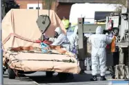  ?? AP PHOTO BY ANDREW MATTHEWS/ ?? Soldiers wearing protective clothing prepare to lift a tow truck in Hyde Road, Gillingham, Dorset, England as the investigat­ion into the suspected nerve agent attack on Russian double agent Sergei Skripal continues Wednesday March 14.