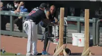  ?? BRYNN ANDERSON – THE ASSOCIATED PRESS ?? Braves veteran outfielder Nick Markakis, right, talks with a coach during team practice at Truist Park in Atlanta Sunday. The 36-year-old Markakis said he was uneasy about playing the season without fans, and was swayed by his telephone conversati­on with teammate Freddie Freeman, who has tested positive for COVID-19 and has symptoms.