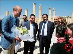  ?? — Reuters ?? Floral welcome: William receiving flowers from locals in the ancient city of Jerash.